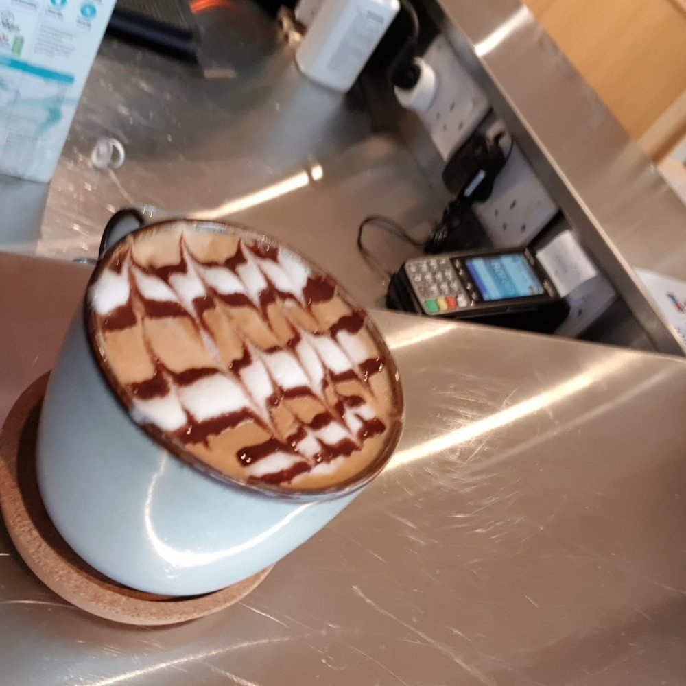 A cappuccino with a chocolate lattice pattern on a light blue cup